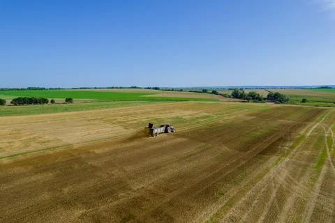 Top view of a red tractor spreading manure from a trailer across a field. Stock Photos