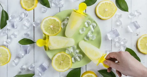 Top view of refreshing lemon popsicles that some people take one by one Stock Footage 130359749