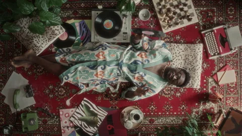 Top View of Relaxed Man Lying on Carpet, Enjoying Vinyl Music from Turntable Stock Footage 339851617