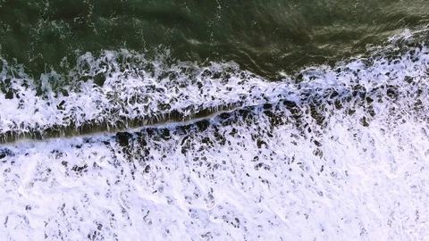 Top view with the removal of the waves of the sea surf with white foam on sand Stock Footage 105678485