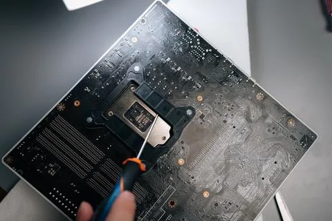 Top view of repairman using screwdriver to carefully remove old thermal paste Stock Photos