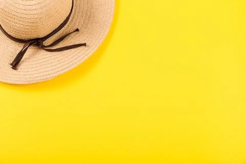 Top view on a retro straw hat on a yellow background. Summer concept. Minim.. Stock Photos