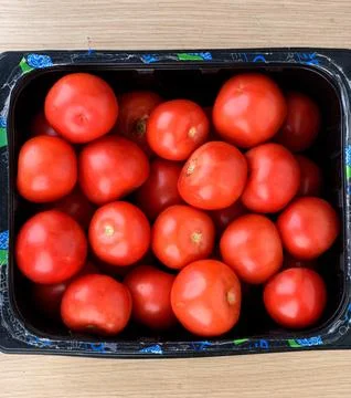 Top view of ripe red tomatoes in black crate. Stock Photos