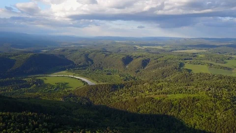Top view of a river in green mountains against a cloudy sky Stock Footage 116535575