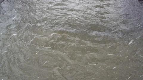 Top view of the river surface, where large flakes of white snow fall on a gloomy 스톡 동영상 141869474