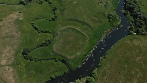 Top view of the river, surrounded by trees and meadows on its banks, view from Stock Footage 109852567