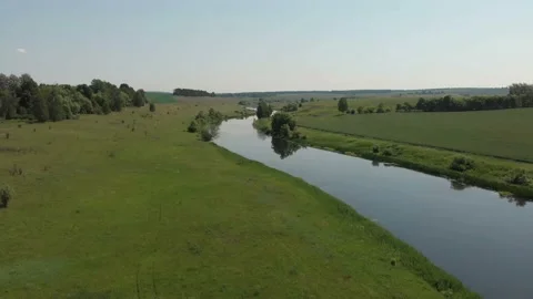 Top view of the river, surrounded by trees and meadows on its banks Stock Footage 111230405