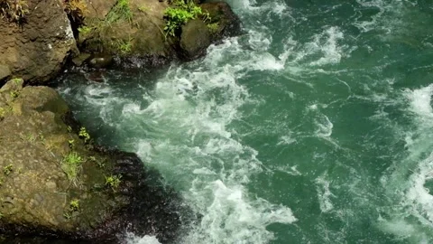 Top view of river water flowing against rocks on the riverbank Stock Footage 320056372