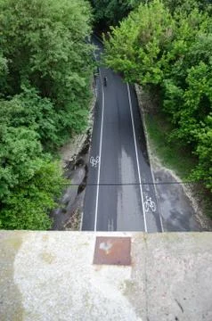 Top view of the road with the cycle path in the forest. Standing on the edge. Stock Photos