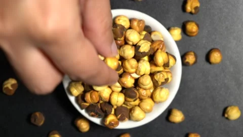 Top view of roasted chickpeas hand taking from bowl Vídeo Stock 139007937