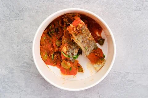 Top view of roasted zander served with steamed tomato, onion and olive sauce  Foto stock
