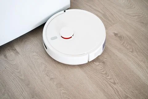 Top view of robot vacuum cleaner on wooden floor, smart home cleaning Stock Photos