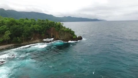 Top view of rocky beach with waves and trees in Indonesia Stock Footage 210215041