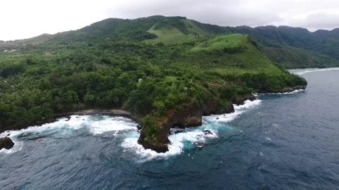 Top view of rocky beach with waves and green mountains in Indonesia Stock Footage 210215070