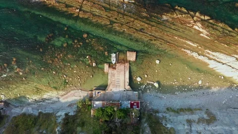 Top view of rocky coastline, down blue sea, little house along the beach. White 스톡 동영상 162816740