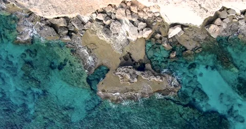 Top view of rocky shore of which is broken by light waves Stock Footage 236697652