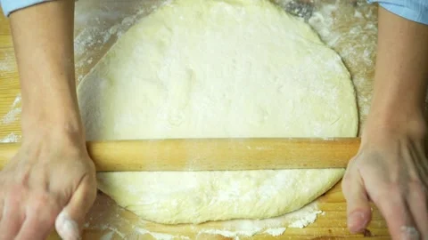 Top view of rolling out the dough on wooden board floured Stock Footage 220683786