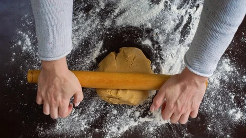 Top view of rolling raw dough with rolling pin Stock Footage 100089890
