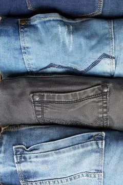 Top view of rolls of various blue jeans. Background from denim pants. Stock Photos