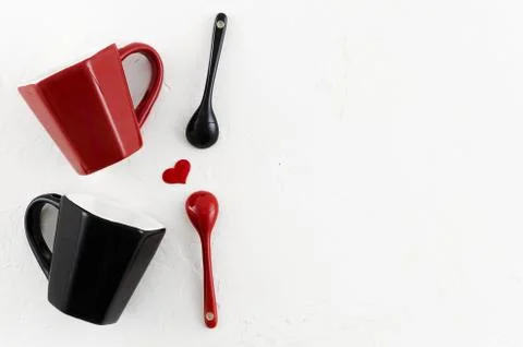 Top view romantic couple's coffee mugs with heart, red and black ceramic spoons Stock Photos