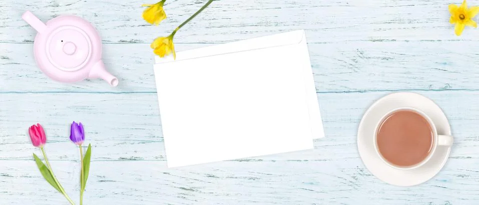 Top view of a romantic scene of a cup of tea, a tea pot, flowers and an envel Stock Photos