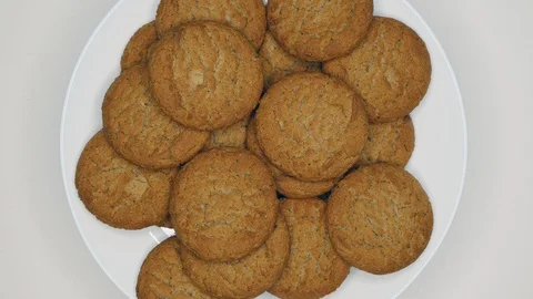 Top View Rotating Close Up Of Fresh Brown Oatmeal Cookies On A White Plate On A  Stock Footage 128589783