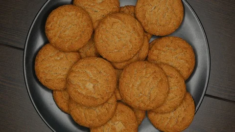 Top View Rotating Close Up Of Fresh Brown Oatmeal Cookies On A Black Plate On A  Stock Footage 128591508