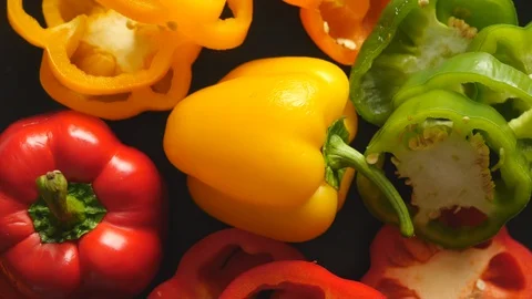 Top View Rotating Close Up Of Sliced Fresh Raw Yellow, Red, Green, Orange Bell P Stock Footage 128626525