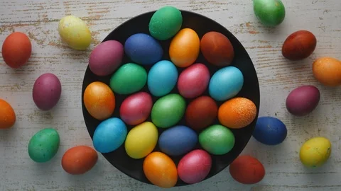 Top View Rotating Of Colorful Easter Eggs Lying On Black Plate On A Wooden Backg 스톡 동영상 126545395