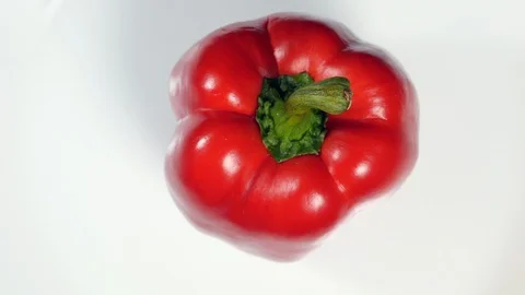 Top View Rotating Fresh Raw Red Bell Pepper On A White Plate. Vídeo Stock 128627265