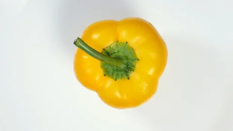 Top View Rotating Fresh Raw Yellow Bell Pepper On A White Plate . Vídeo Stock 128627368