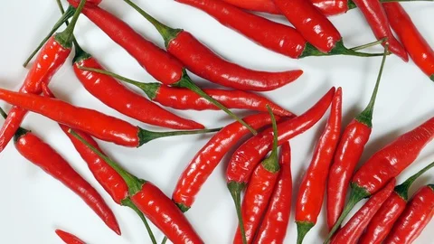 Top View Rotating Fresh Raw Red Chili Peppers On A White Plate . Stock Footage 128627430