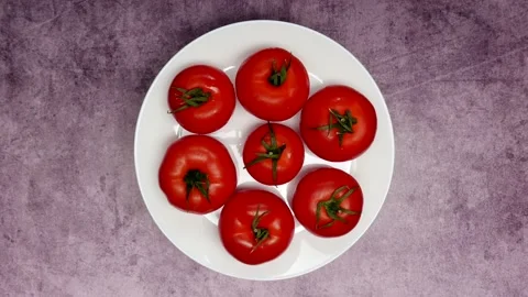 Top View Of Rotating Fresh Red Raw Tomatoes On A White Plate On A Purple Marble  Stock Footage 151261217