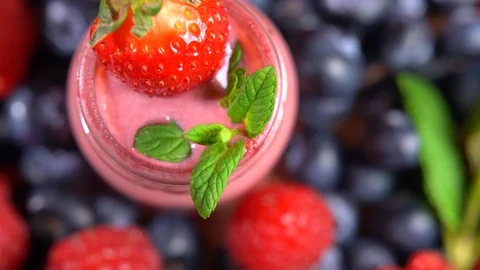Top view of rotating fruit smoothie, fresh protein yogurt with strawberries and 스톡 동영상 117858686