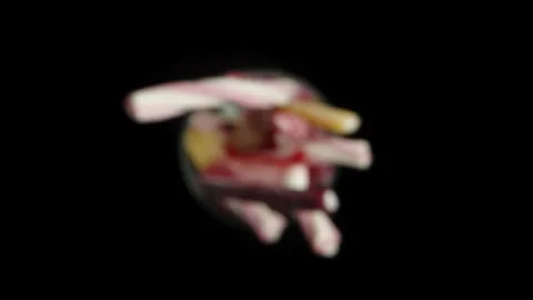 Top view of a rotating glass filled to the top with a mix of gummy candies duste Stock Footage 249571339