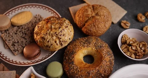 Top view rotating macro of assorted macarons with bagel and walnuts on plate Stock Footage 320171012
