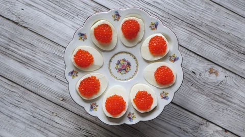 Top View Rotating Of Red Caviar On Eggs On An Egg Dish On Gray Wooden Background Vídeos de archivo 128707714