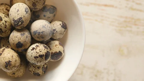 Top View Rotating Of Uncooked Quail Eggs In A White Plate On A Light Background  스톡 동영상 128629077