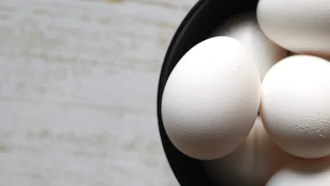 Top View Rotating Of Uncooked White Chicken Eggs In A Black Plate On A L Stock Footage 128629027