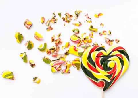 Top view of roughly broken lollipops on colorful white background Stock Photos