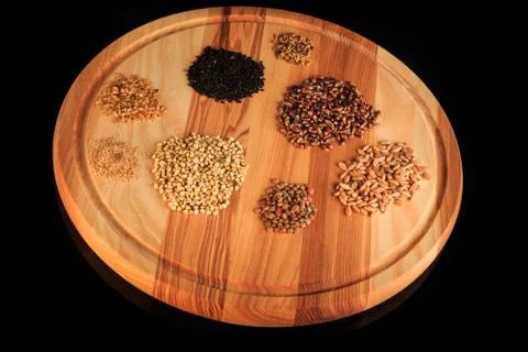 Top view on round board with assorted groat handfuls Stock Photos