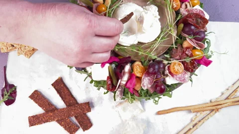 Top view of a round cheese, sausage and vegetable appetizer plate, with soft che Stock Footage 304457797
