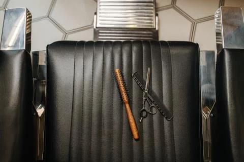 Top view of round comb, classic straight comb and shears on hairdresser's chair Stock Photos
