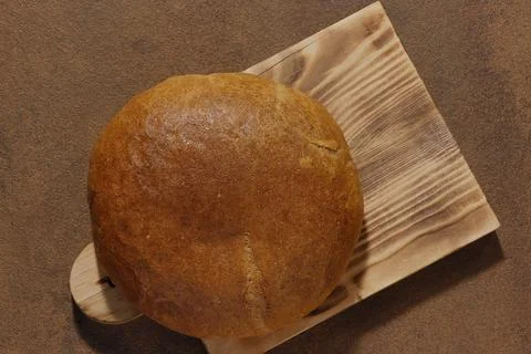 Top view of a round loaf of bread on a cutting board. Stock-Fotos