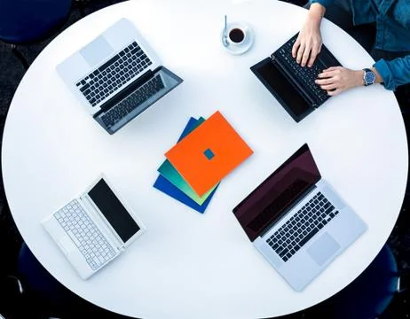 Top View of Rounded Desk with Four Laptops Stock Photos