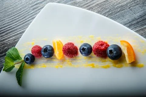 Top view on row of blueberry, raspberry and sliced orange 写真素材