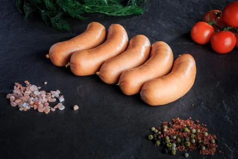 Top view row of short thick sausages with dill and tomatoes Fotos de archivo