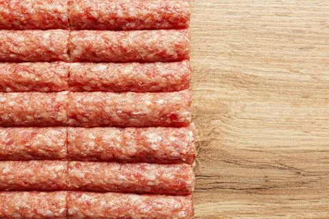 Top view of rows of fresh raw ground meat on wooden board Stock Photos