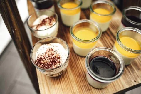 Top view rows of glasses with various sweet vanilla of fruit dessert on wooden Stock Photos