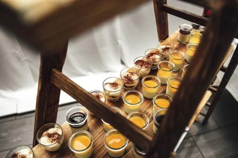 Top view rows of glasses with various sweet vanilla of fruit dessert on wooden Stock Photos